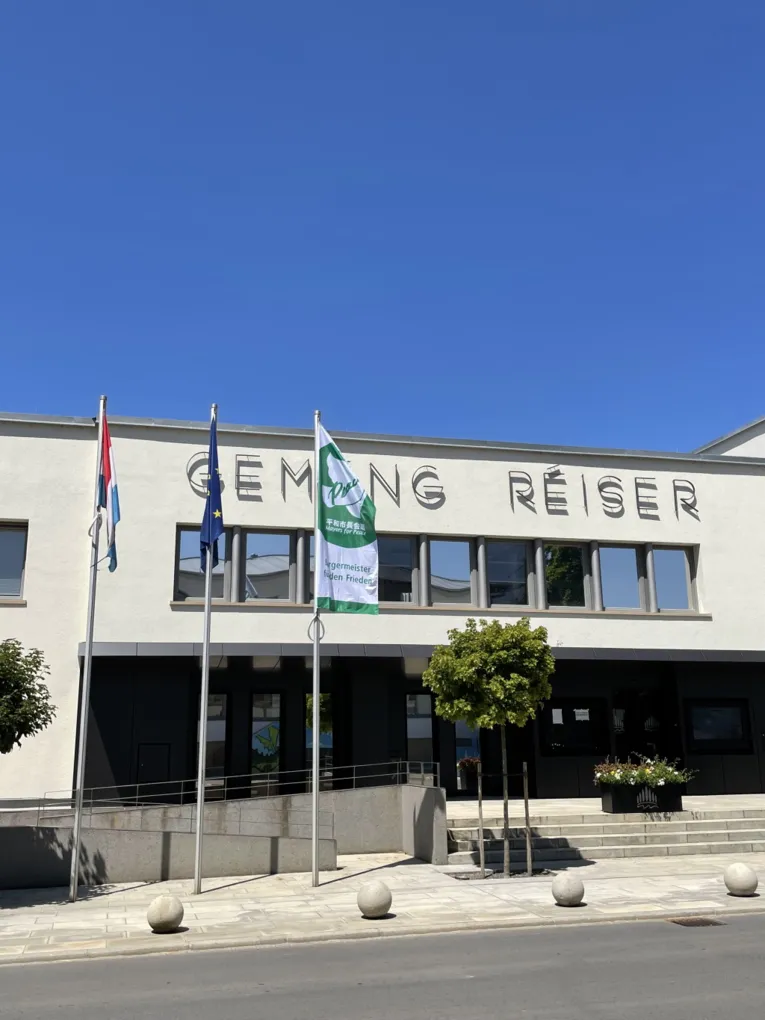 Die mayors-for-Peace-Flagge vor einem Geb&auml;ude in Roeser (Luxemburg)
